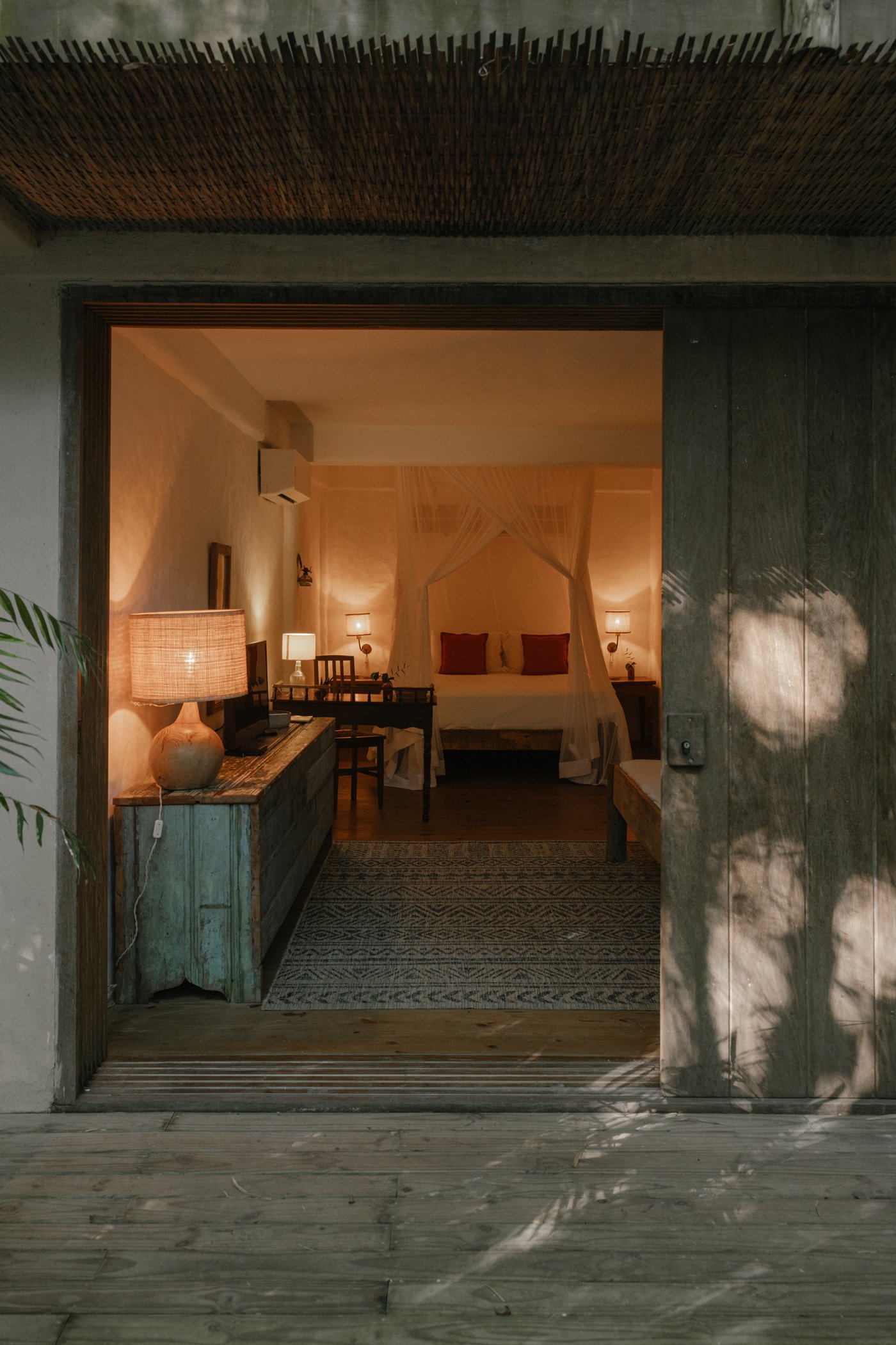 Doorkijk naar een kamer met bed onder de klamboe