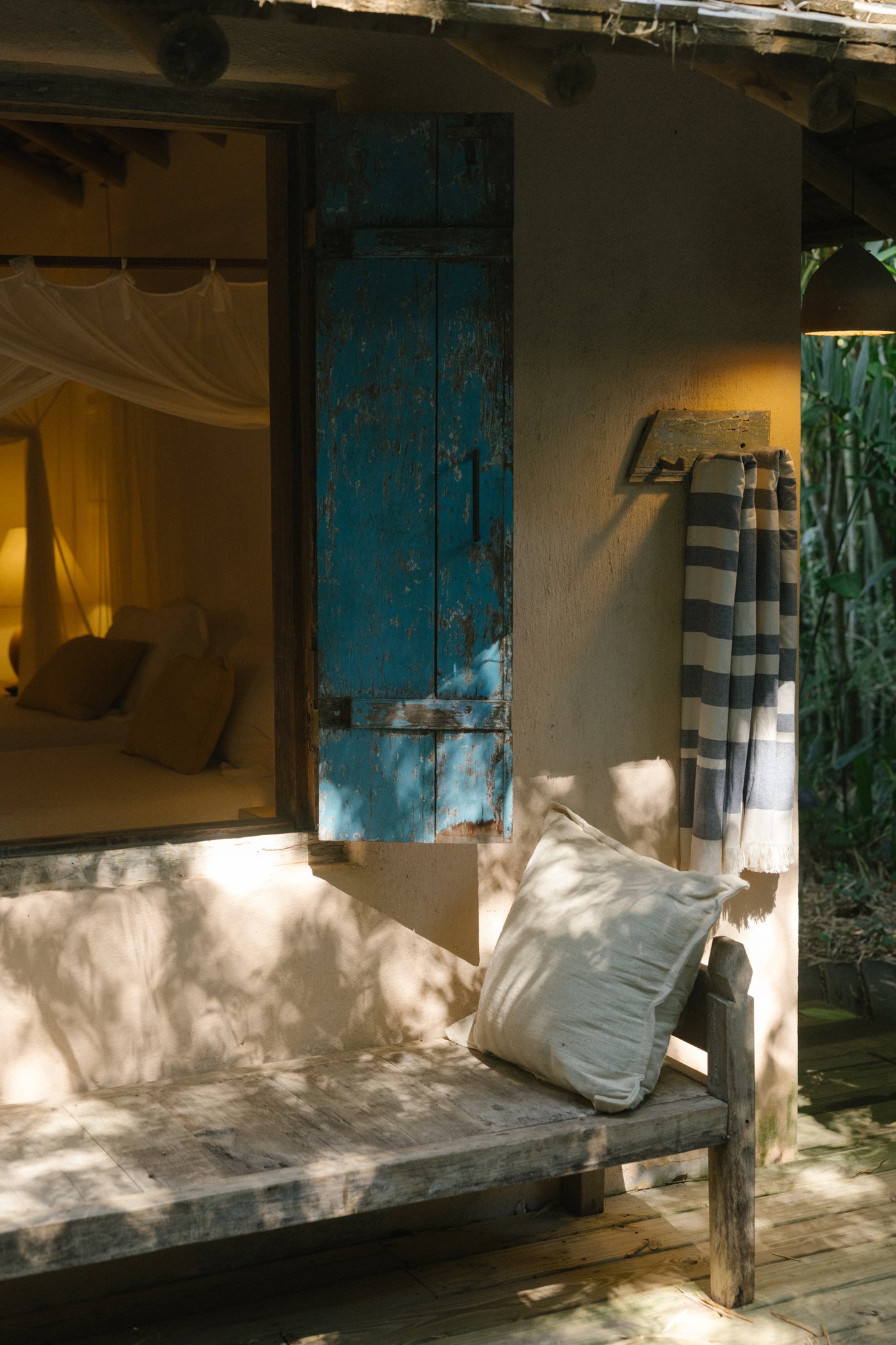 Bankje voor de kamer met blauw luik