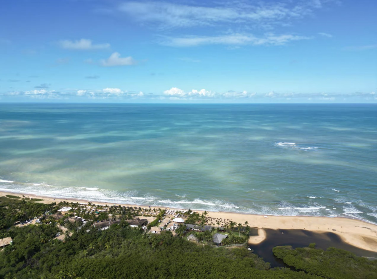 Luchtfoto van het strand van Trancoso, met palmbomen, jungle en de oceaan